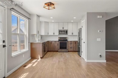 Kitchen with white cabinets, sink, light stone cou