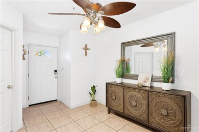 Foyer entrance featuring light tile patterned flooring and ceiling fan