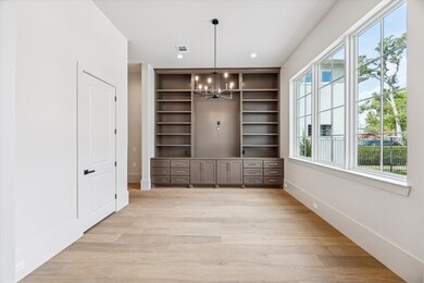 View of the study with built-in bookshelves and cabinets.  There is an adjacent half bath.
