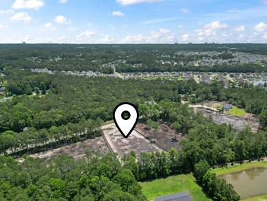 View of property location with a forest and a nearby body of water