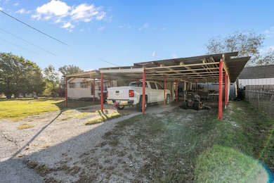 View of vehicle parking with driveway and a carport