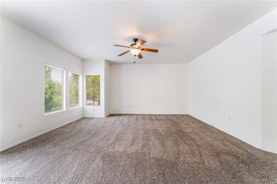Carpeted spare room featuring ceiling fan and base
