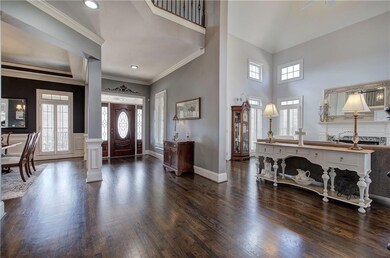 Entryway featuring dark wood-style floors, crown molding, and recessed lighting
