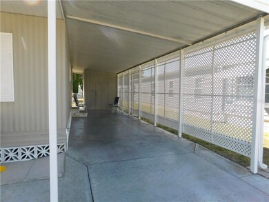 Carport area is enclosed with lattice.