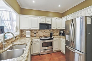 Kitchen featuring white cabinetry, sink, light sto