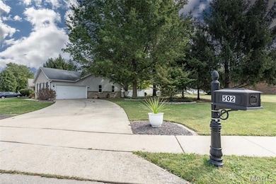 View of front of home featuring a front lawn, driveway, and an attached garage