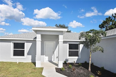 Doorway to property with a lawn, stucco siding, and roof with shingles