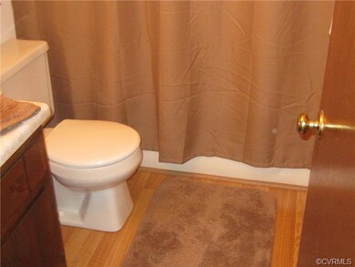 Hall bath with laminate wood floors.