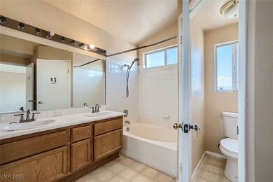 Full bathroom featuring toilet, double vanity, sho