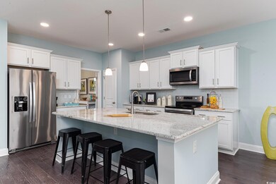Kitchen featuring appliances with stainless steel finishes, a sink, dark wood-type flooring, decorative backsplash, and recessed lighting