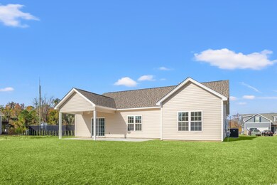 Rear view of house featuring a lawn, central air condition unit, and a patio
