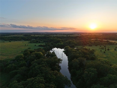 Drone / aerial view of a nearby body of water and a forest