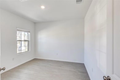 Spare room with light wood-type flooring and baseboards
