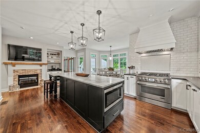 Kitchen with a kitchen island, stainless steel appliances, premium range hood, dark hardwood / wood-style floors, and pendant lighting