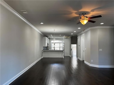 Unfurnished living room featuring a ceiling fan, b