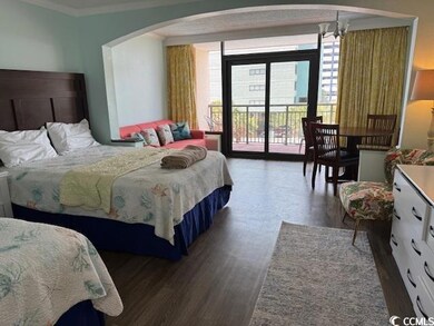 Bedroom featuring arched walkways, access to exterior, wood finished floors, a chandelier, and ornamental molding