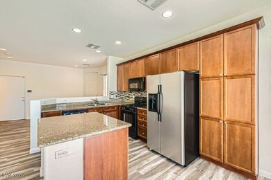 Kitchen with black appliances, a sink, light wood-