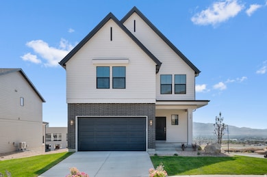 View of front facade featuring a porch, concrete driveway, a front yard, brick siding, and a garage