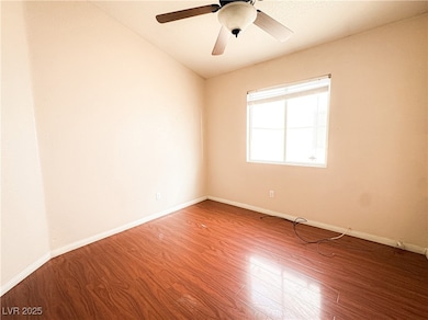 Spare room featuring wood finished floors, baseboa