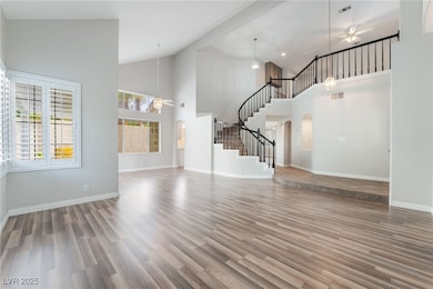 Unfurnished living room featuring ceiling fan, arc