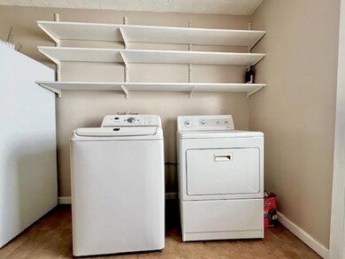 Washroom with washer and dryer and light colored carpet