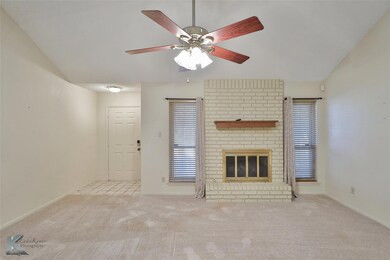 Unfurnished living room featuring a brick fireplac