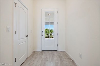 Entryway with baseboards and light wood finished f