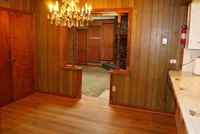 wood walls, a chandelier, and light hardwood / woo