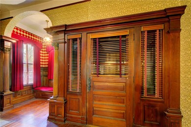 foyer. note detailed columns, velvet wallpaper