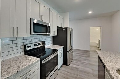 Kitchen featuring light stone counters, stainless
