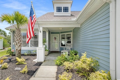 Entrance to property with covered porch and a shingled roof