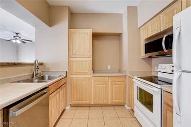 Kitchen with stainless steel appliances, light brown cabinetry, light countertops, and light tile patterned floors