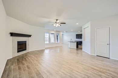 Unfurnished living room featuring ceiling fan, a f