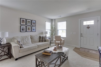 Living area with light carpet, baseboards, and vis