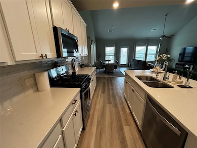 Kitchen with stainless steel appliances, wood fin