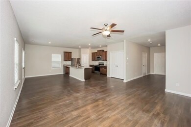 Unfurnished living room featuring ceiling fan, bas