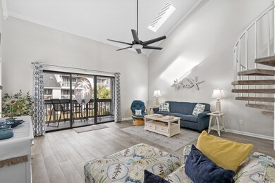 Living room featuring a towering ceiling, a skylig