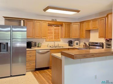 Kitchen with appliances with stainless steel finishes, a peninsula.