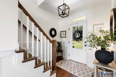 Foyer with dark wood-type flooring and stairs