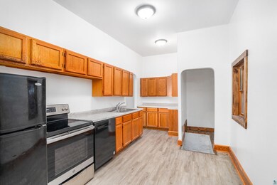 Kitchen with black appliances, light hardwood / wo