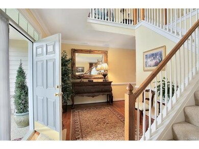 The foyer features a stunning staircase leading to