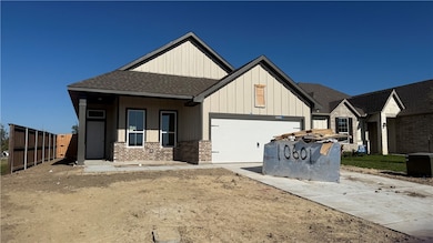 View of front of property with roof with shingles, a porch, board and batten siding, brick siding, and driveway