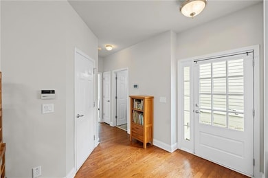 Foyer with light wood-style floors and baseboards