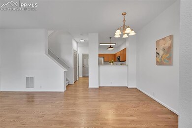 Unfurnished living room featuring light wood-style floors, a chandelier, and stairway