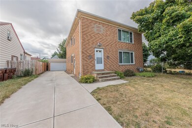 View of front of house with a garage, an outbuilding, and a front yard