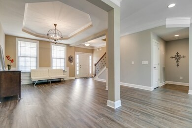 This space includes an octagonal trey ceiling with crown molding, LVP flooring, chair rail, wainscot, oil-rubbed bronze light fixture, and a pass-through to the Family Room for ease of entertainment.