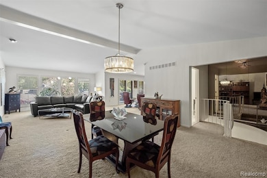 Carpeted dining room with a chandelier