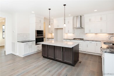 Kitchen with white cabinets, dark stone counters,