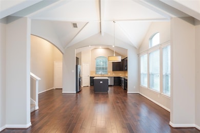 Unfurnished living room with dark wood-style floo