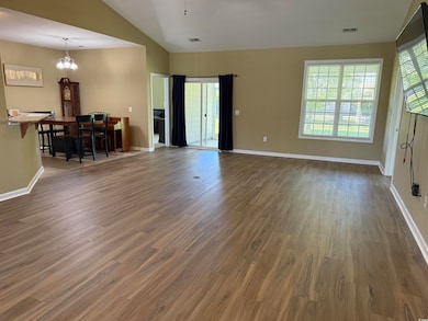 Living room featuring visible vents, a chandelier,